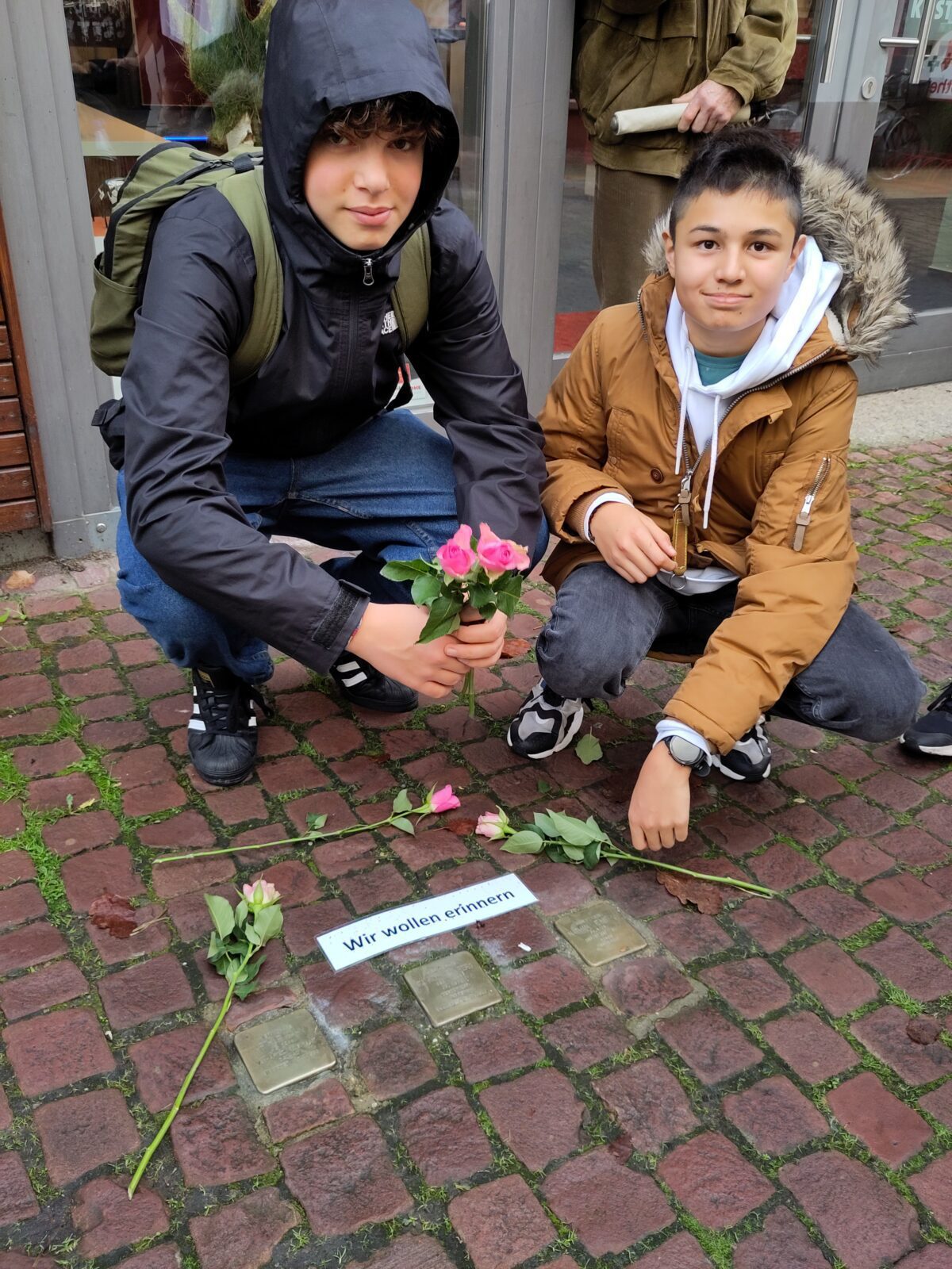 Zeichen des Erinnerns: Max Ringel und Ludwig Fürsch aus der Klasse 8b am FLG legen Blumen an Stolpersteinen nieder.