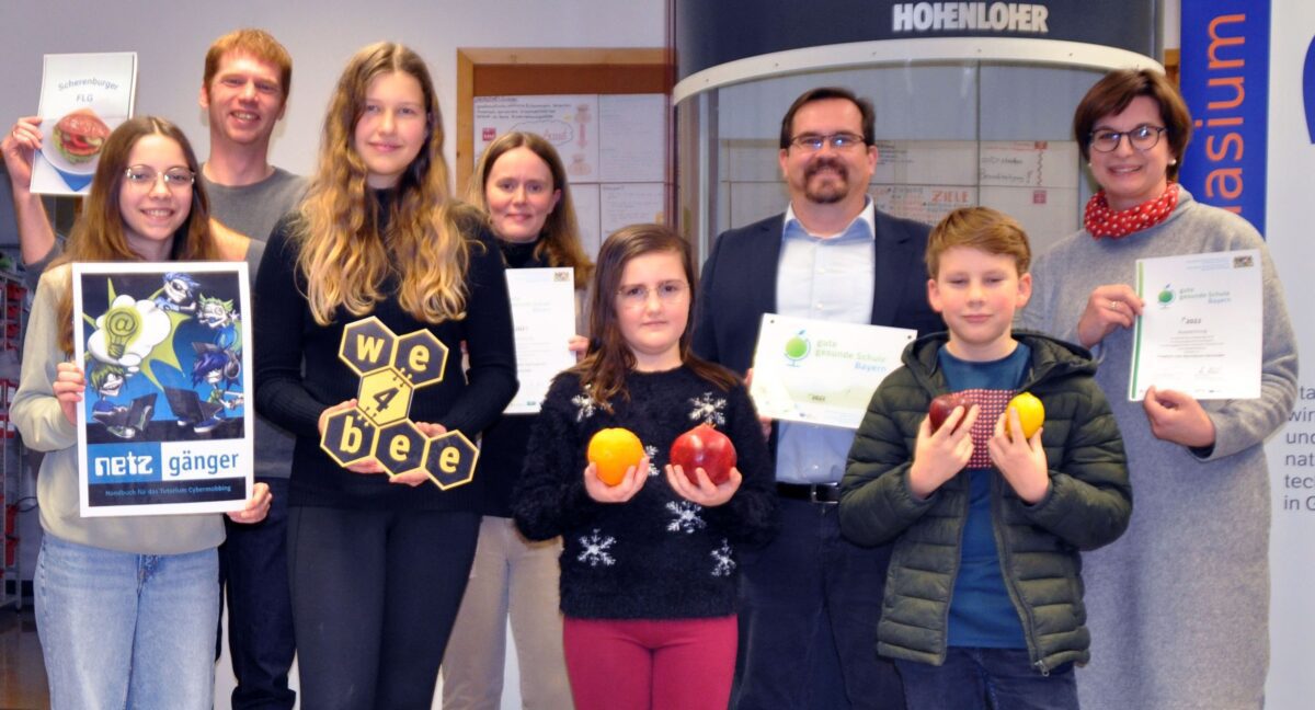 Viele Auszeichnungen für ausgezeichnete Angebote am FLG: Schulleiter Ingo Schneider und Lehrerin Eleonore Hose freuen sich mit engagierten Schülerinnen und Schülern.